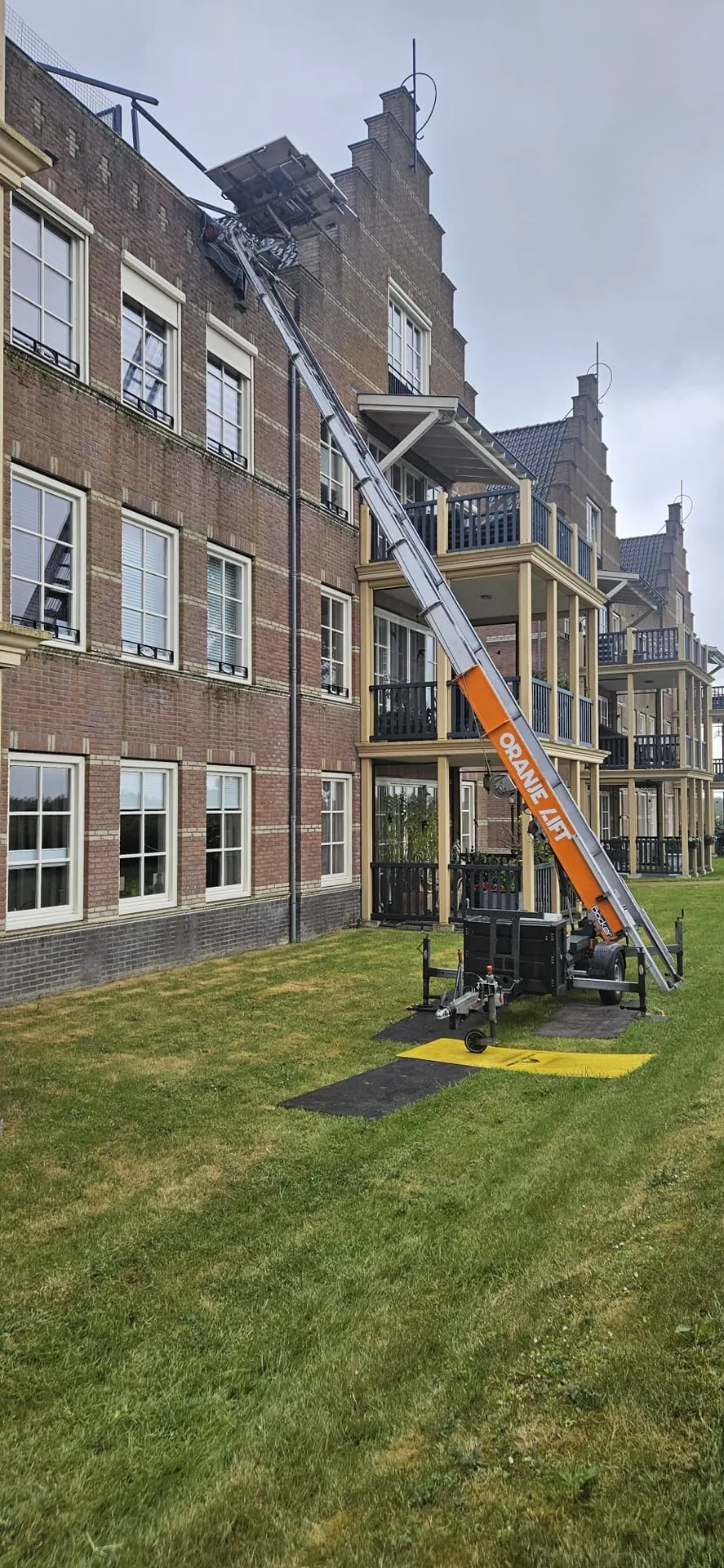 Aanhangerlift bij een groot gebouw met tuin