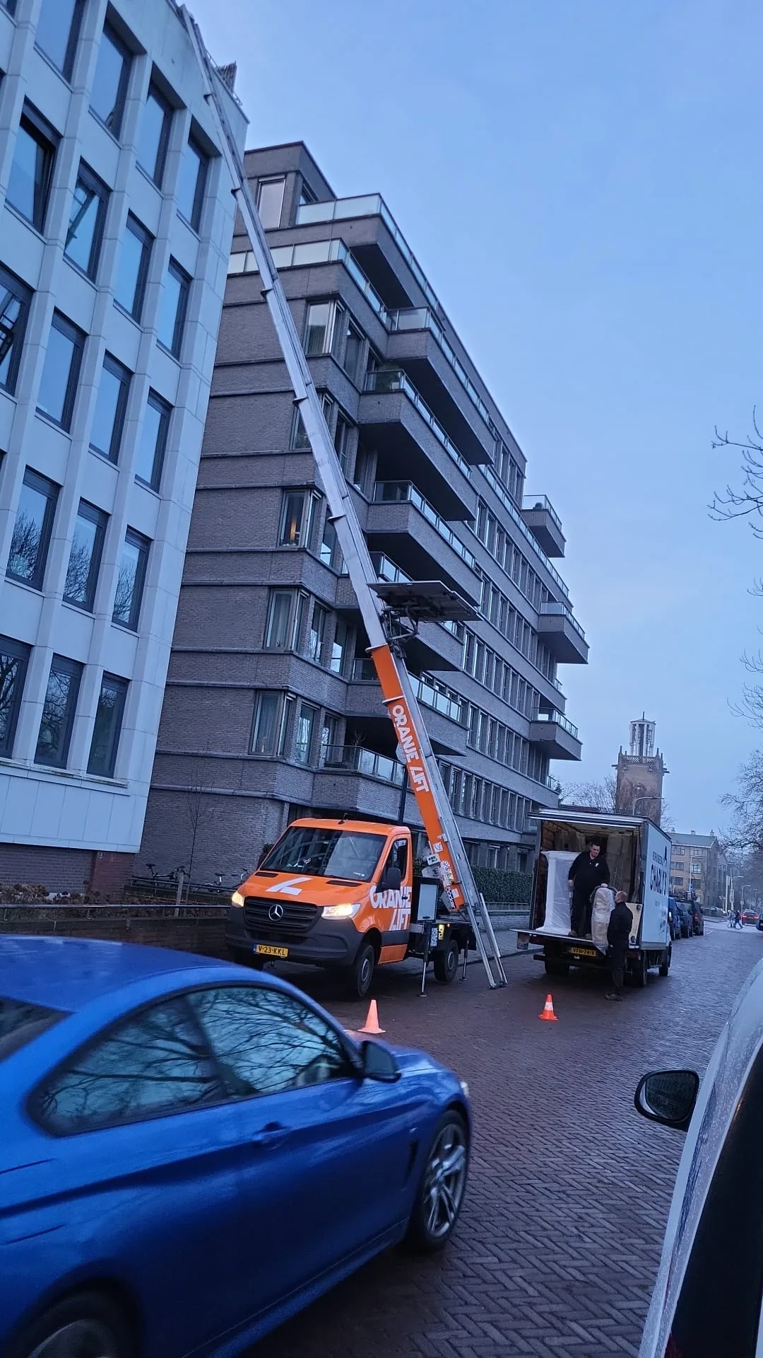 Ladderlift reikt tot bovenste verdieping van hoog flatgebouw met balkons